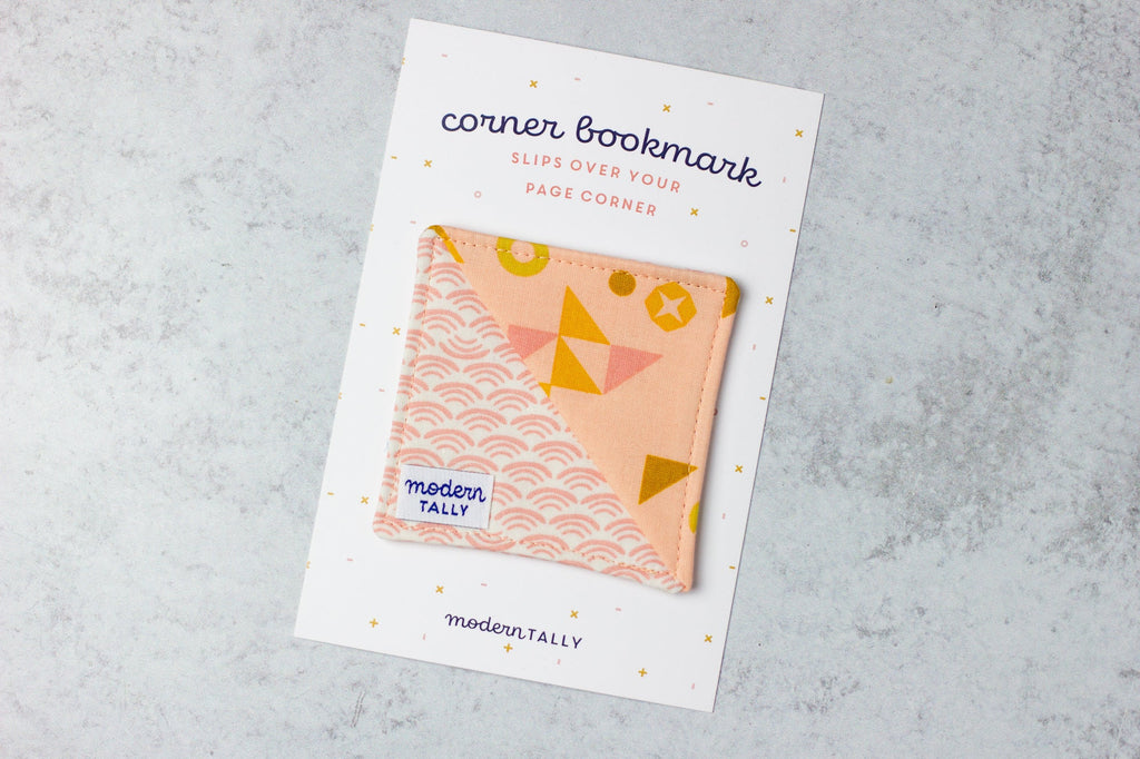 Corner bookmark handmade out of fabric, peach with geometric designs.