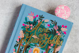 close up of a beautifully illustrated copy of Anne of Green Gables with a neon pink bookmark in it